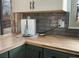 Kitchen counter with an coffee maker, stylish backsplash, and butcher block countertops at 9510 Flower St, Broomfield, CO 80021