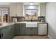 A delightful kitchen featuring a farmhouse sink and stainless steel dishwasher below a window at 9510 Flower St, Broomfield, CO 80021