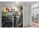 Laundry area including an LG washer and dryer with extra storage above and access to the bathroom at 9510 Flower St, Broomfield, CO 80021