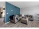 Contemporary living room boasting gray floors, a striking blue accent wall, and plush seating at 9510 Flower St, Broomfield, CO 80021