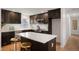 Modern kitchen with dark cabinetry, quartz countertops, and island at 4751 S Xenia St, Denver, CO 80237