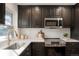 Modern kitchen with dark cabinetry, stainless steel appliances, and quartz countertops at 4751 S Xenia St, Denver, CO 80237