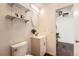 Compact bathroom with a single vanity and shelves for storage, and view to bedroom at 13020 E Linvale Pl, Aurora, CO 80014
