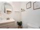 Updated half bathroom with gray vanity, round mirror, and decorative shelving at 13020 E Linvale Pl, Aurora, CO 80014