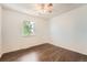 Bright bedroom featuring hardwood floors, a window letting in natural light, and a ceiling fan at 13020 E Linvale Pl, Aurora, CO 80014