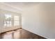 Well-lit bedroom with two windows, dark wood floors, and baseboard heating at 13020 E Linvale Pl, Aurora, CO 80014