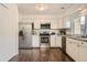 Well-lit kitchen featuring stainless steel appliances, white cabinets, and granite countertops at 13020 E Linvale Pl, Aurora, CO 80014