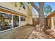 Back patio with mature trees, privacy fence, and sliding glass doors leading indoors at 13020 E Linvale Pl, Aurora, CO 80014