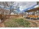 Private backyard with green grass, wood fence, a shed, and patio with pergola at 9821 Rock Dove Ln, Highlands Ranch, CO 80129