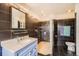 Modern bathroom with dark tile, a walk-in shower with glass block, and a marble countertop sink at 9821 Rock Dove Ln, Highlands Ranch, CO 80129