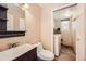 Compact bathroom and laundry room featuring a toilet, vanity, mirror, and a stacked washer and dryer at 9821 Rock Dove Ln, Highlands Ranch, CO 80129