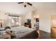 Sunlit bedroom with hardwood floors, ceiling fan, and a view of the en-suite bathroom and walk-in closet at 9821 Rock Dove Ln, Highlands Ranch, CO 80129