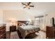 Bright bedroom with hardwood floors, ceiling fan, and a large window overlooking the neighborhood at 9821 Rock Dove Ln, Highlands Ranch, CO 80129