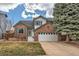 Charming two-story home featuring a brick facade, white siding, well-maintained lawn, and an attached two-car garage at 9821 Rock Dove Ln, Highlands Ranch, CO 80129