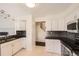 Updated kitchen with white cabinets, stainless steel appliances, and black countertops for a modern, clean look at 9821 Rock Dove Ln, Highlands Ranch, CO 80129