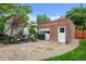 Outdoor patio area with an umbrella, backyard seating and a detached brick garage at 1429 Hudson St, Denver, CO 80220