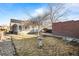 An outdoor space with a birdbath, bare lawn, and a brick detached garage, offering potential for landscaping and personalization at 1429 Hudson St, Denver, CO 80220