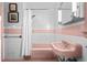 Retro bathroom features pink tiles, a pink sink, and a bathtub with shower, with white walls at 1429 Hudson St, Denver, CO 80220