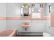 Retro bathroom features pink tiles, a pink sink, and a bathtub, with white walls and a window at 1429 Hudson St, Denver, CO 80220