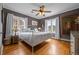 Cozy bedroom featuring hardwood floors, large windows, ceiling fan, and warm gray paint at 1429 Hudson St, Denver, CO 80220