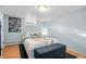 Light blue bedroom with modern art, a comfortable bed, and bench seating at 1429 Hudson St, Denver, CO 80220