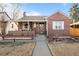 Charming brick home with a covered porch, sidewalk to the street and manicured front lawn at 1429 Hudson St, Denver, CO 80220