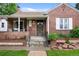 Close-up of a well-maintained brick home highlighting the front porch, stylish door, and inviting curb appeal at 1429 Hudson St, Denver, CO 80220
