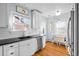 Bright kitchen features white cabinets, stainless steel appliances, and hardwood floors at 1429 Hudson St, Denver, CO 80220