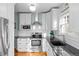 Well-lit kitchen features stainless steel appliances, granite countertops, white cabinets, and tile backsplash at 1429 Hudson St, Denver, CO 80220