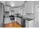 Bright kitchen with stainless steel appliances, granite countertops, and white cabinets at 1429 Hudson St, Denver, CO 80220