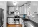 Updated kitchen featuring stainless steel appliances, white cabinets, and granite countertops at 1429 Hudson St, Denver, CO 80220