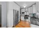 Modern kitchen with stainless steel appliances, white cabinets, and hardwood floors at 1429 Hudson St, Denver, CO 80220