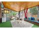 Bright sunroom showing wood ceiling, turf carpet and access to outside at 1429 Hudson St, Denver, CO 80220