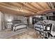 Spacious unfinished basement with exposed beams, concrete walls, and multiple beds at 20710 E Princeton Pl, Aurora, CO 80013