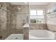 Well-lit bathroom featuring a tub and shower combination with stylish tile and glass surround at 20710 E Princeton Pl, Aurora, CO 80013