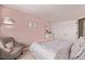 Comfortable bedroom with pink walls and a sitting chair, offering a quiet retreat at 20710 E Princeton Pl, Aurora, CO 80013
