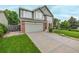 Attractive two-story home boasts a well-kept lawn, brick details, and a spacious driveway at 20710 E Princeton Pl, Aurora, CO 80013