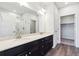 Bathroom featuring double vanity, a large mirror, and a glass enclosed shower and walk-in closet at 485 Interlocken Blvd # 201, Broomfield, CO 80021