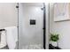 Modern shower with gray tiling, stone flooring, black trim and decor at 9141 Gail Ct, Thornton, CO 80229