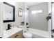 This bathroom features light gray tiling, a shower/tub combo, and modern fixtures at 9141 Gail Ct, Thornton, CO 80229
