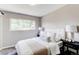 Cozy bedroom features a plush upholstered headboard, soft lighting, and a large window for natural light at 9141 Gail Ct, Thornton, CO 80229