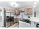 Modern kitchen with stainless steel appliances, gray backsplash, bright countertops, and open bar seating at 9141 Gail Ct, Thornton, CO 80229