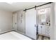 This main bedroom features a sliding barn door and en-suite bathroom with modern vanity and lighting at 9141 Gail Ct, Thornton, CO 80229