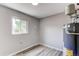 Neutral-toned utility room with gray vinyl floors, a window with natural light, and a modern water heater at 9141 Gail Ct, Thornton, CO 80229