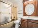 Bathroom featuring a shower-tub combo with a frosted door and a vanity with wood trim and oval mirror at 1800 Centaur Village Dr, Lafayette, CO 80026