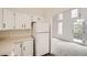 Efficient kitchen with white appliances and cabinets, seamlessly connected to the adjacent living space at 1800 Centaur Village Dr, Lafayette, CO 80026