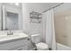 Bright bathroom features a single sink vanity, neutral tile tub surround and shower curtain at 9031 Apache Plume Dr # E, Parker, CO 80134