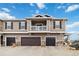 Street view of townhome showcasing a balcony and attached two-car garage at 9031 Apache Plume Dr # E, Parker, CO 80134