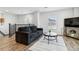 Townhome living room featuring wood floors, modern furniture, and bright natural light at 9031 Apache Plume Dr # E, Parker, CO 80134