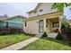 A well-maintained backyard with a grassy area and concrete pathway leading to the house at 10671 E 28Th Ave, Denver, CO 80238